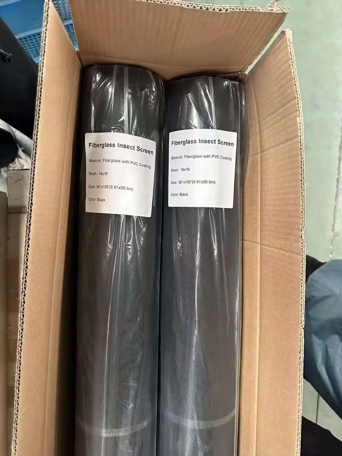 Two black fiberglass insect screen rolls packed in a carton with visible 18×16 product labels