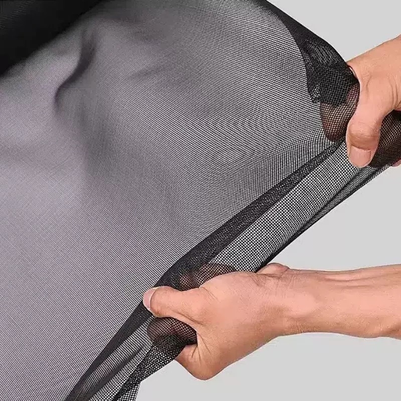 Hands holding black screen mesh to show flexibility and weave