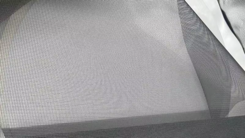 Black screen mesh held open to show the weave and visibility