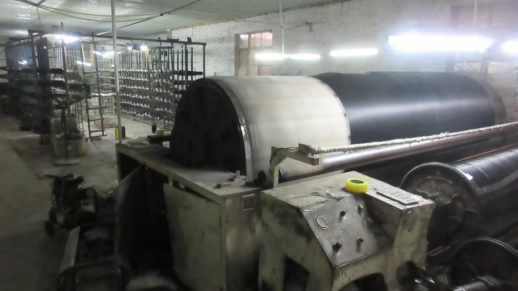 Wide screen mesh material moving through warping equipment